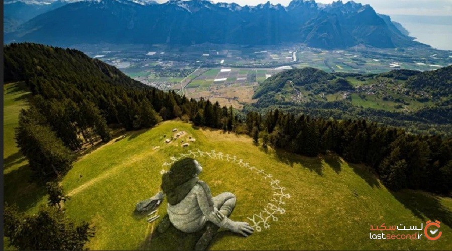 نقاشی بزرگ بروی چمن و با موضوع ویروس کرونا در کوه های الپ