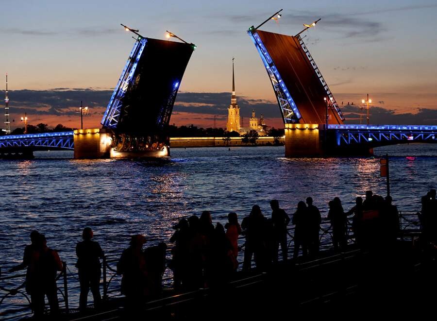 گردشگران در حال تماشای باز شدن پل در شب‌های سفید روسیه.jpg